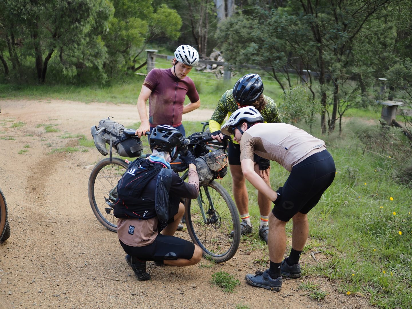 4 men looking at a bike