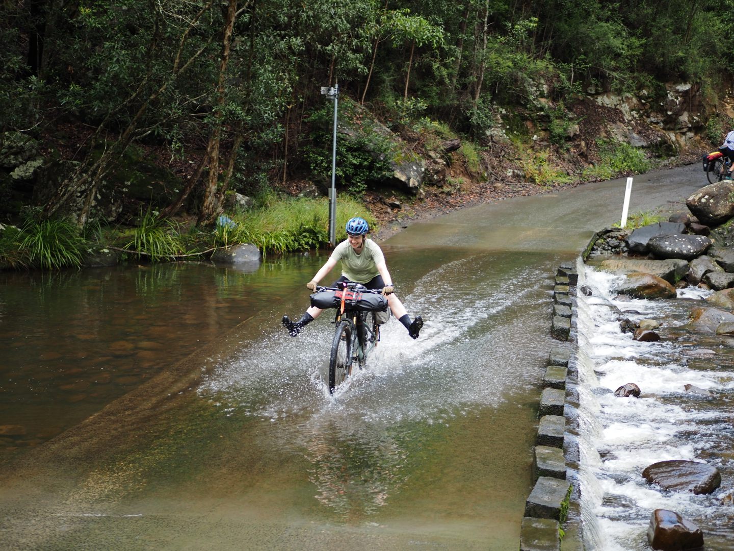 cylist crossing river with jets of water