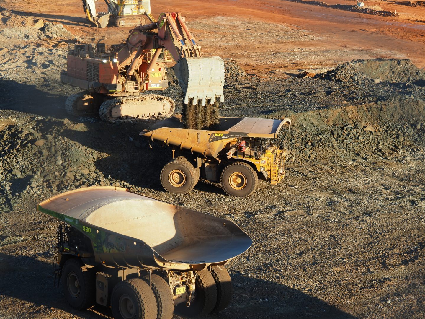 Digger filling dump truck